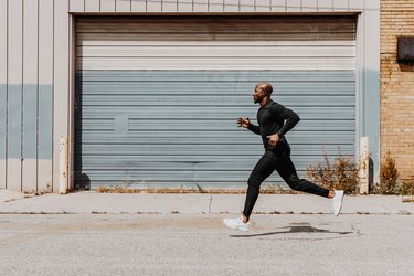 A person in black exercise clothes runs outside to show how long they can run without stopping.