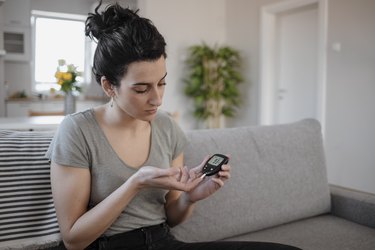 Women Checking Blood Sugar Levels by Glucose Meter