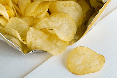 Bag of potato chips spilling onto white table