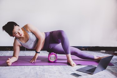 Asian woman working out while watching tutorials online