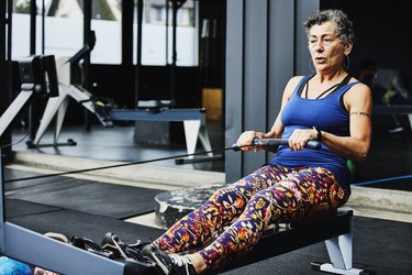 Senior woman working out on rowing machine at outdoor gym