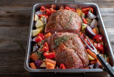 Preparation of pork roast with herbs and vegetables in a baking pan, using cola as a marinade