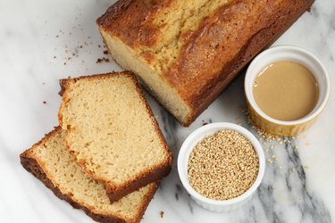 sesame seeds in bowl on table with tahini and bread