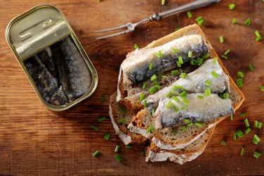 Toast with purine-rich sardines in canned oil on a wooden board