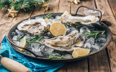 Plate of raw oysters on wooden table are iron-rich foods for elderly