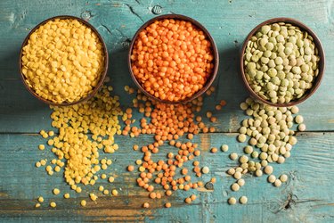 overhead shot of protein-rich red yellow and green lentils on teal wooden table