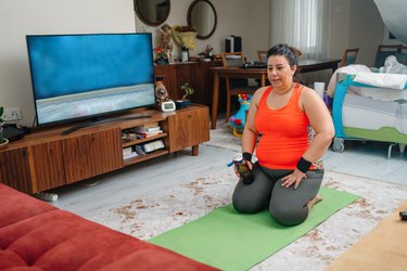 Woman performing workout video at home.