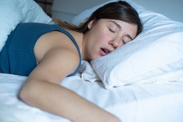 Close up of woman breathing through her mouth while asleep, which can contribute to dry mouth