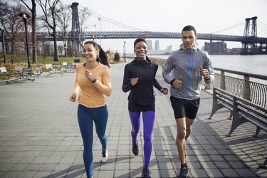 runners on footpath with Williamsburg Bridge in background