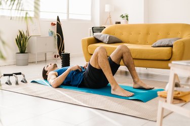 Tired person laying on yoga mat demonstrating exercising when tired