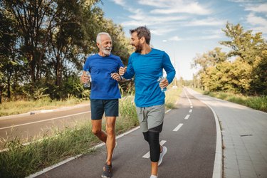 a senior man and young man running together