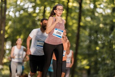 Determined runner burning calories and running a marathon in nature.