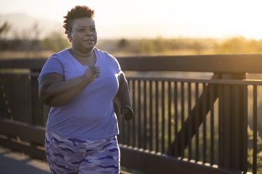 a woman walking 10 miles for weight loss outside at sunrise