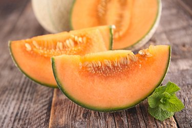pieces of fresh Cantaloupe melon on wooden background