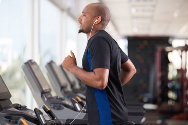 Side view of person doing a treadmill workout in a gym in the winter