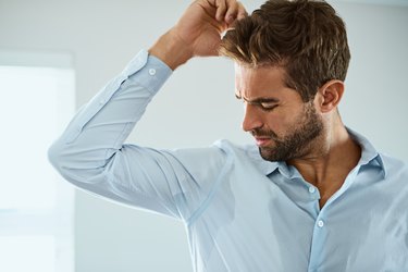 A man sweating through his shirt at work