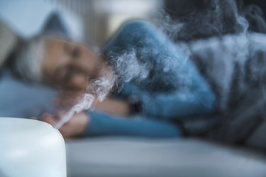 woman sleeping with an air humidifier to get rid of post-nasal drip