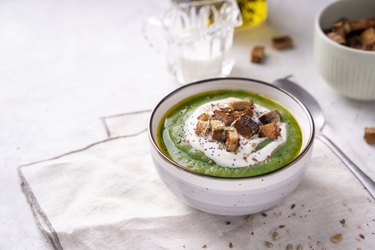 Rustic spinach and broccoli rich soup puree with cream and croutons