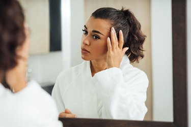 Young Woman Looking In Mirror