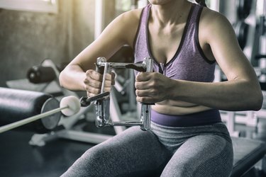 Close-up of a person lifting weights at the gym.