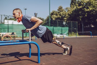 Person doing incline triceps push-ups outdoors at park.