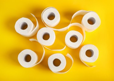 Toilet paper rolls in a pattern on a yellow background