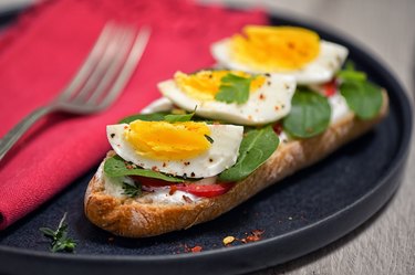 Meal with soft boiled eggs, toast, yogurt and spinach