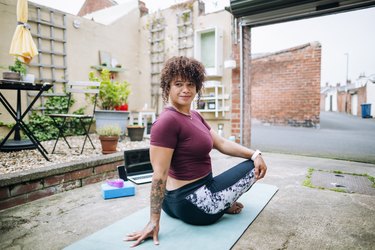 woman on a rooftop doing seated spinal twist, one of the best yoga poses for digestion