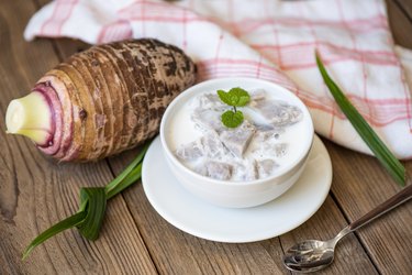 Taro food with dessert taro boiled with sugar and coconut milk on bowl and fresh raw organic taro root ready to cook, Asian Thai food