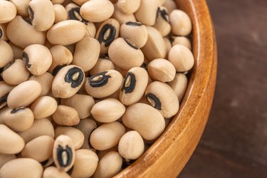 Kidney black eyed beans in rustic wooden bowl close up. Dry uncooked legumes