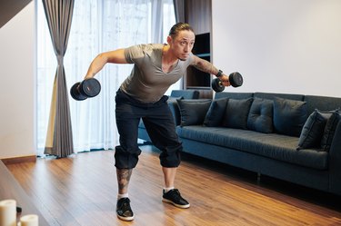 man doing dumbbell rear delt fly in living room