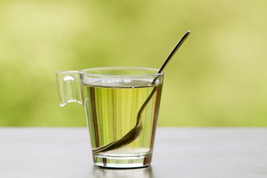 Glass of green tea with spoon