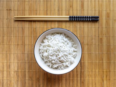Bowl Of White Rice And Chopsticks On Mat