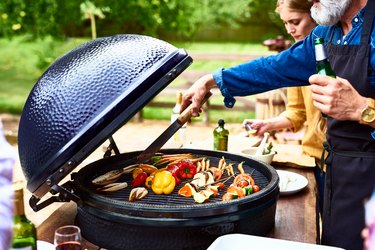 a person cooking vegetables on a grill outside