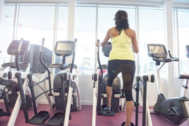 Rear view of mature woman at gym on step machine