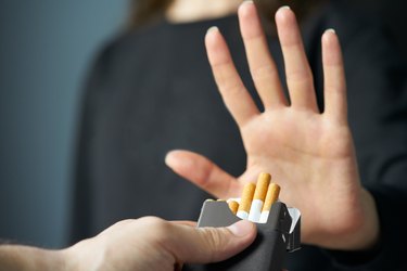 A person's hand refusing cigarettes, as a natural remedy for upset stomach