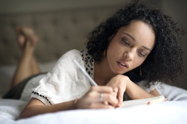 Woman writing in her gratitude journal to stop racing thoughts at night