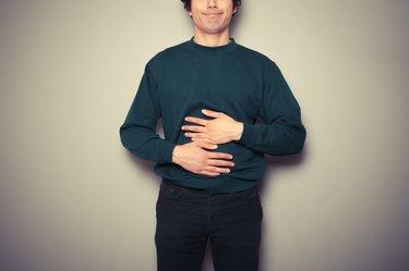 Young man rubbing his stomach