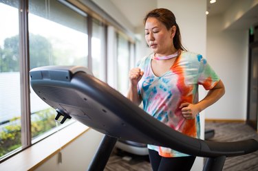 A woman running on a treadmill at a gym