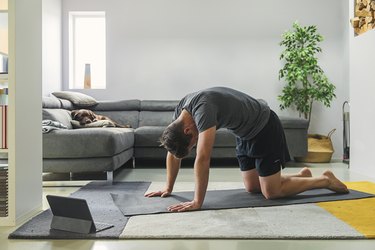 man in a grey shirt doing range of motion exercises in living room