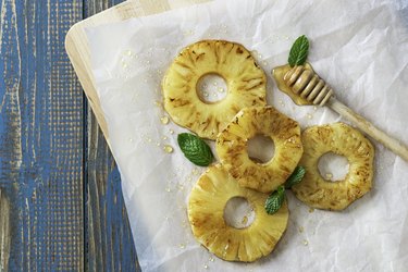 Grilled Pineapple and Honey on Wax Paper on a Blue Wooden Table