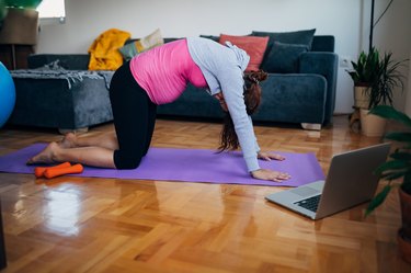 Pregnant woman doing cat-cow yoga pose for bladder control