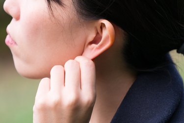 Woman doing an ear massage or acupressure, as a natural remedy for earache