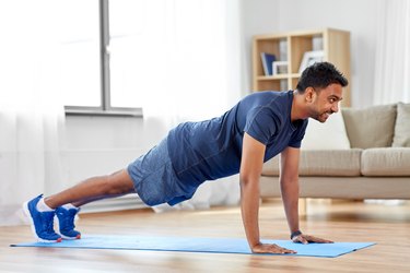 Person doing push-ups at home in living room.