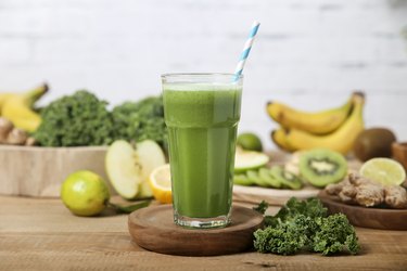 Green smoothie surrounded by ingredients
