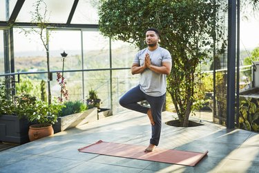 Person practicing tree pose on yoga mat where they are better at balancing on their non-dominant leg.