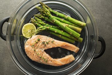 Steamed salmon with asparagus and lemon in a steamer