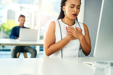 person holding chest with heartburn related to progesterone