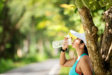runner with dry mouth drinking from water bottle outside