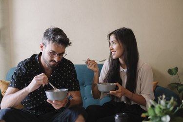 Young couple siiting on a couch in a cafe having breakfast